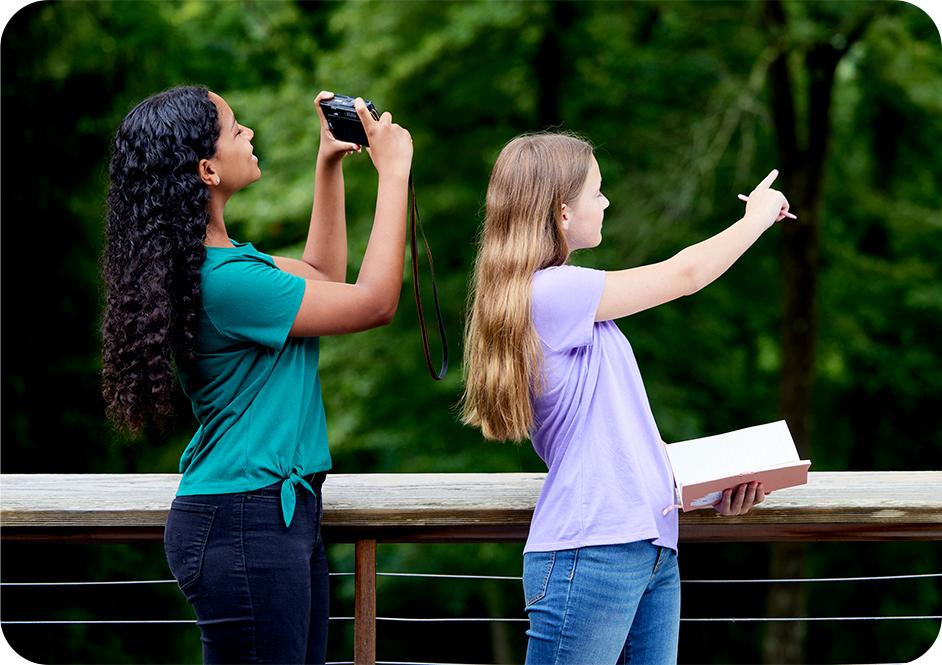 Girl wearing light purple long sleeve shirt and tan Girl Scouts uniform vest