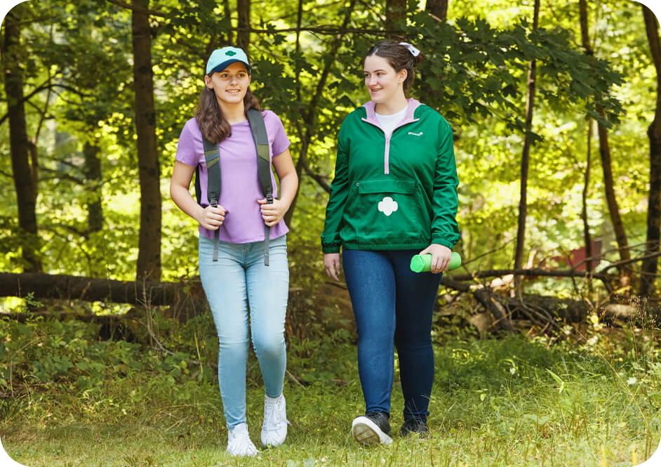Two girls hiking wearing Girl Scouts clothing