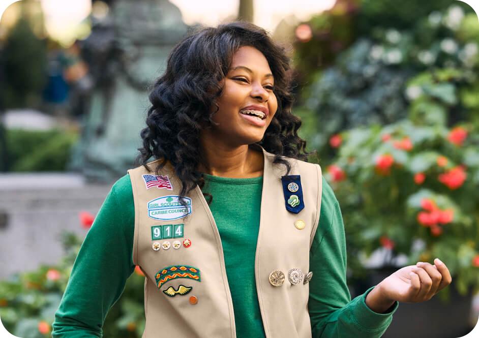  Girl wearing green long sleeve shirt with tan Girl Scouts uniform vest